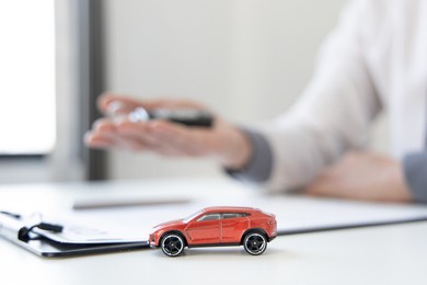 car dealers or insurance managers cover and protect against damage and the risk of driving, hold the car keys, protecting and after-sales care concept.