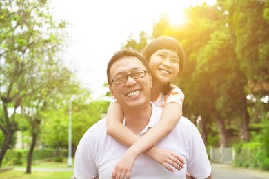 happy father and little girl with sunset background