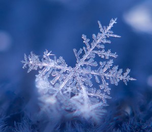 snowflake with one broken branch on blue background