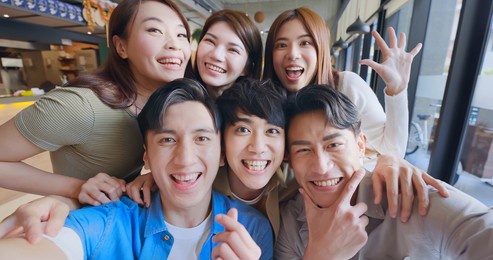 asian young six friends taking selfie in restaurant happily