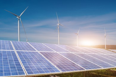 solar panels with wind turbines against blue sky background. photovoltaic, alternative electricity source. sustainable resources concept.