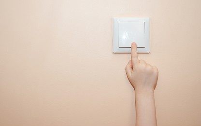 the child's hand turns off the light .