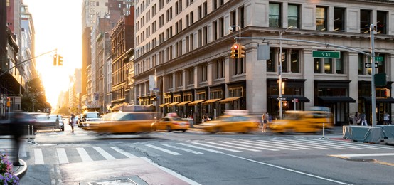 yellow taxis driving through the busy intersection of 5th avenue and 23rd street in manhattan, new york city usa