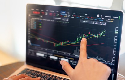 the business woman investor trading or stock brokers having a planning and analyzing with display screen and pointing on the data presented and deal on a stock exchange.