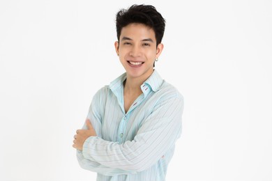 young and handsome teenage black hair asian man wearing earrings cross arms pose on white background.