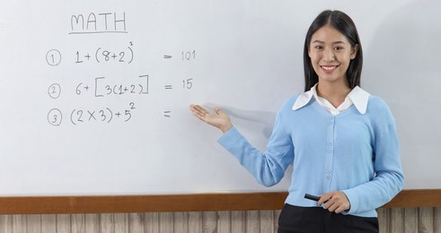 asian teachers are teaching mathematics classes in addition, subtraction, multiplication, and division in high school or university classrooms, math quiz on a white board.