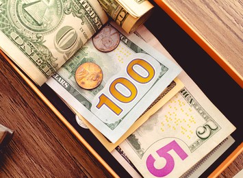 dollar bills in a small box to save money. us money - usd, money background. concepts of economy, personal finance and saving money.

