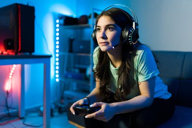 beautiful young woman focusing on winning a video game with a remote controller. female gamer enjoying a video game in a console during a leisure day in her bedroom