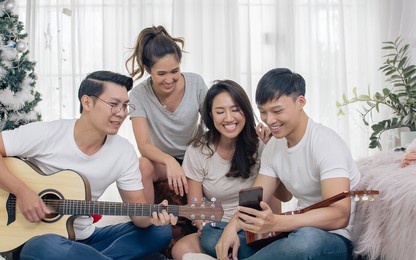 group of asian friends having party, playing guitar and singing together with fun at home. lifestyle concept.