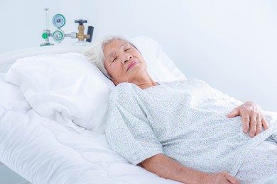 senior woman lying in bed at hospital ward. medicine, health care and people concept.