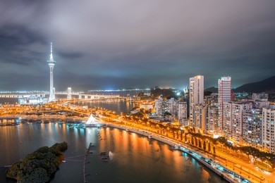 macau, china. aerial view of city buildings and tower at night.