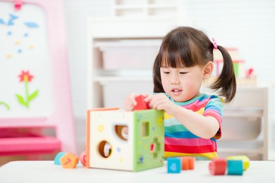 young girl playing number shape blocks for homeschooling