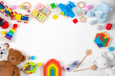 baby kids toys frame. set of colorful educational wooden and fluffy toys on white background. top view, flat lay, copy space for text