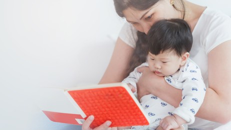 young happy asian woman reading book with the little baby boy. development education concept.