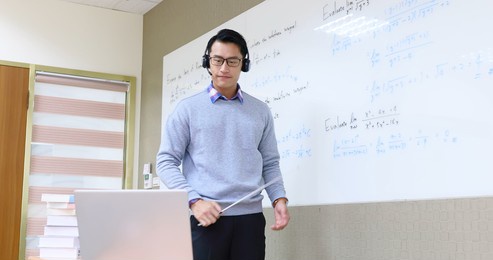 asian male professor teach calculus online through laptop in classroom