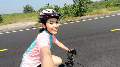 asian female cyclist blogger live stream happily to show her ride on the road