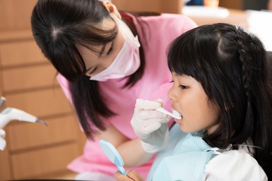 a girl brushing her teeth at a dental clinic