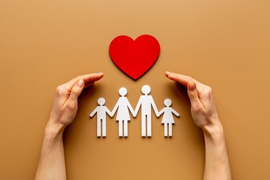 hands holding family figure. life and health insurance concept.
