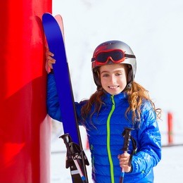 kid girl winter snow with ski equipment helmet goggles poles
