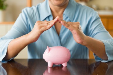 hands of people cover above pink piggy bank for saving money and financial