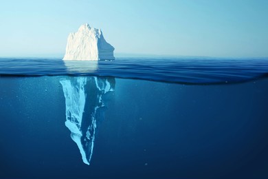 iceberg in clear blue water and hidden danger under water. iceberg - hidden danger and global warming concept. floating ice in ocean. copyspace for text and design