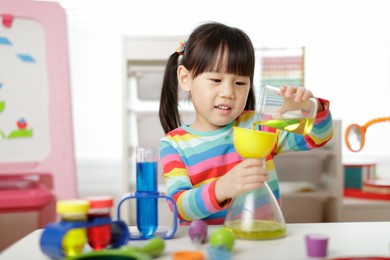 young girl playing color sorting and fine motor skill toy at hom