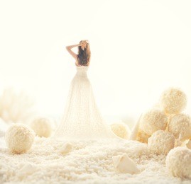 woman in white dress in a fairy world of big candies. unusual modern art