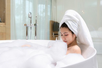 happy asian woman bathes with white foam in a bathtub fun emotions.