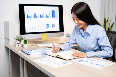 asian women sit at their desks and calculate financial graphs showing results about their investments, plan a successful business growth process.