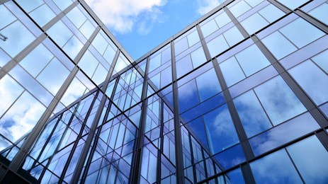modern office building with glass facade on a clear sky background. transparent glass wall of office building.