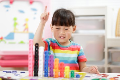 young girl play number blocks for home schooling 