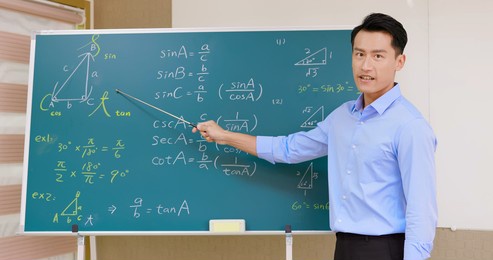 asian senior high school male teacher teach math online through webcam in classroom