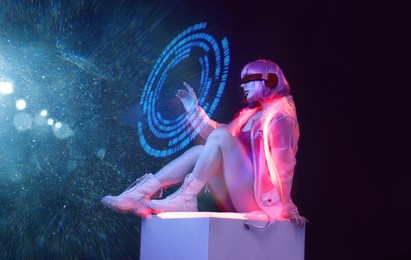 beautiful woman with purple hair in futuristic costume on dark background. girl in glasses of virtual reality. augmented reality game, future technology, ai concept. holographic interface.
