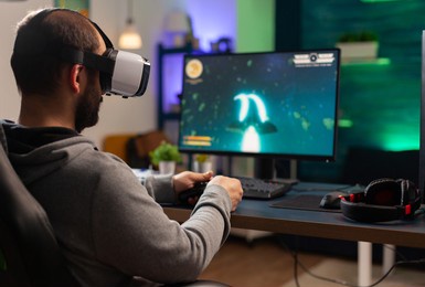 competitive gamer playing e-sport championship using technology network wireless professional man wearing vr headset and play online space shooter competition on powerful computer