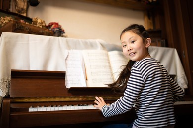 girl playing the piano at home