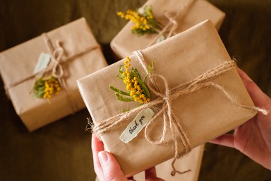 female hands holding gift boxes decorated with yellow flowers a thank you. appreciate concept. top view. high quality photo