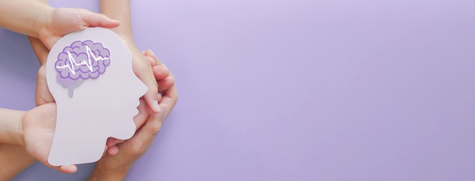 adult and child hands holding encephalography brain paper cutout,autism, stroke, epilepsy and alzheimer awareness, seizure disorder, stroke, adhd, world mental health day concept