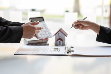 real estate broker agent presenting and consult to customer to decision making sign insurance form agreement, buy and sell home model, concerning mortgage loan offer for and house insurance