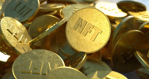 nft golden coins in pile. non fungible tokens dropped casually in a large pile, close-up shot. embossed circuit design, shiny gold color with bright sunlight. trendy cryptocurrency art coins.