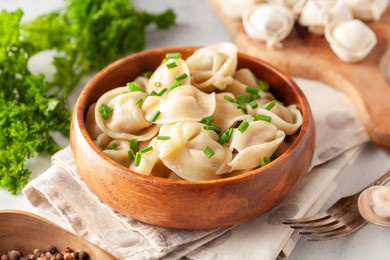 homemade meat dumplings with onions and parsley- russian pelmeni in wooden bowl.