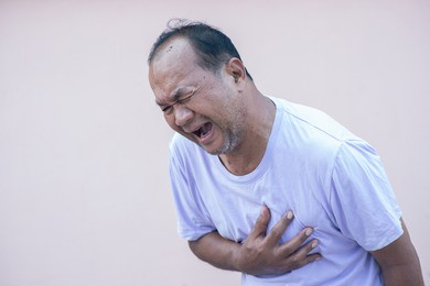 senior male asian  holding his heart in pain and suffering from bad pain in his chest heart attack, senior heart disease