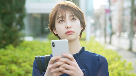 young asian woman using a smart phone on the street.