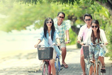 carefree group friends having fun and smiling riding bicycle during the summer day