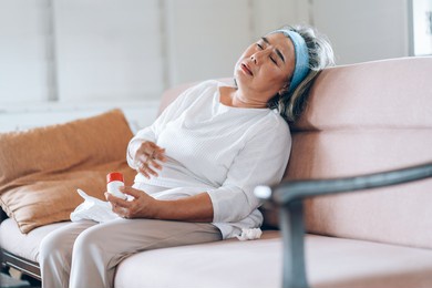 old asian woman holding breast because of heart infarction at home.