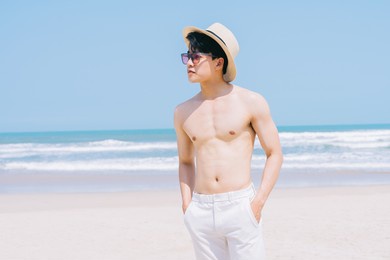 young asian man walking on the beach