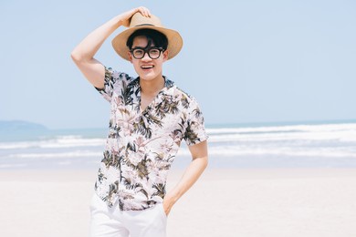 young asian man walking on the beach