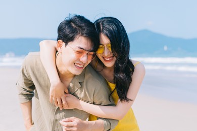 young asian couple enjoying summer vacation on the beach
