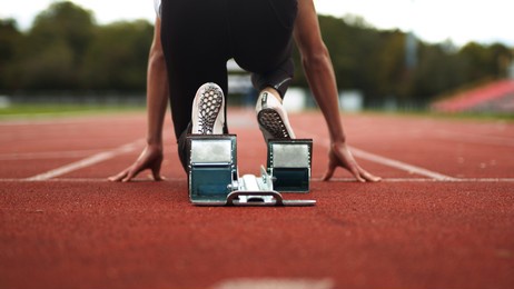 track and field athlete being ready in the blocks alone with no competition, sprinter, empty lanes, lonely, training, practise, spikes