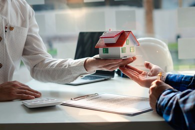 buying a home or insurance, an insurance agent explains the lease agreement to a client before making a contract. mortgage loan approval home loan and insurance concept.

