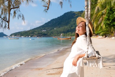 portrait image of a beautiful young asian woman with swing by the sea